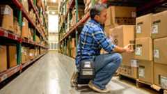 Man Bending Down Warehouse Aisle Blog Photo