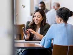 A colleague is showing their mobile computer to a co-worker in professional setting. A colleague is showing their mobile computer to a co-worker in professional setting.