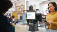 Retail cashier processing a purchase on a Zebra Interactive Kiosk. Retail cashier processing a purchase on a Zebra Interactive Kiosk.