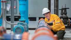 An engineer using a handheld mobile computer to inspect a water pump. An engineer using a handheld mobile computer to inspect a water pump.